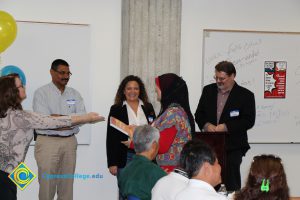 Staff looking on as a student receives an award.