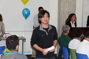 A smiling young man holding a book.