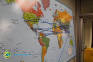 World map showing locations connected by string.