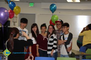 A young lady taking a picture of a group of students.