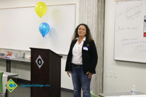 Woman in a white blouse, black blazer and blue jeans.