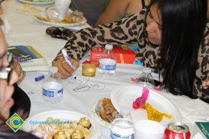 Students writing on a paper tablecover.