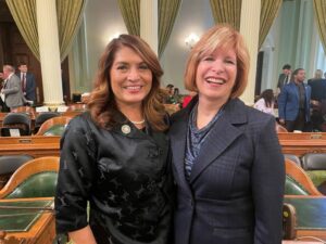 This photo shows Assemblywoman Sharon Quirk-Silva on the left with her arm around Cypress College President Dr. JoAnna Schilling. The two women are standing on the floor of the California Assembly. Photo taken March 20, 2023.