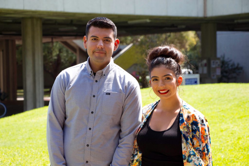 Woman in flowery top and man in gray long-sleeved shirt, smiling