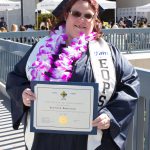 EOPS graduate holding a certificate.