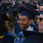 Cypress College graduate smiling while seated during the commencement ceremony,