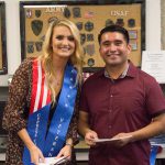 Young lady with blonde hair wearing a Veteran stole standing with Juan Garcia.