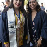 Two female graduates in graduation regalia.