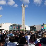 View of commencement guests seated with campanile in the background.