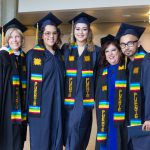 Dr. Therese Mosqueda Ponce in graduation regalia with other staff and students from the Puente Program.