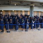 Students in graduation regalia, lined up and waiting for commencement to start.