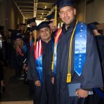 Students in graduation regalia, lined up and waiting for commencement to start.