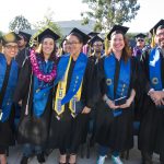 Smiling graduates in cap and gown.