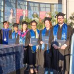 Dr. Cheryl Marshall, Dr. Schilling standing on commencement stage with BSF graduates.