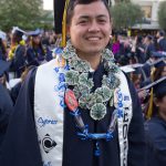 Young man in graduation regalia smiling.