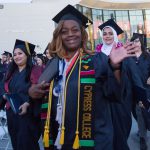 Cypress College graduates smiling at the camera.