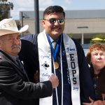 An EOPS graduating student standing with an older couple.