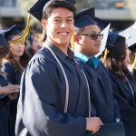 A smiling male graduate during commencement.