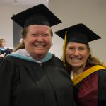 Jolena Grande and another woman wearing graduation regalia.