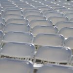 Rows of empty white chairs.