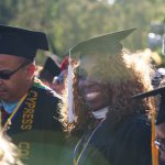 Dr. Regina Rhymes in her academic regalia smiling during commencement.