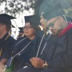 Students in graduation regalia seated during commencement.