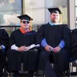 NOCCCD Chancellor Cheryl Marshall and Board of Trustee Members in graduation regalia seated on stage during commencement.