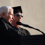 Two men speaking at commencement.