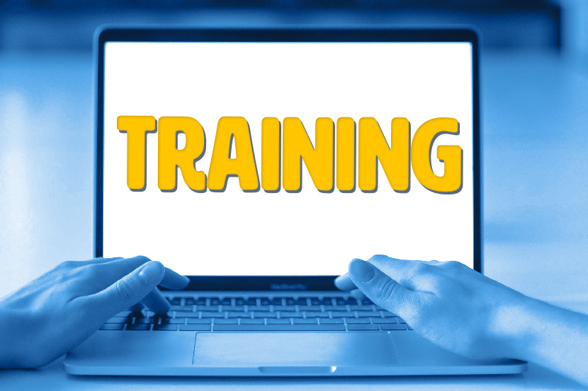 Hands typing on a laptop. The laptop reads "Training"