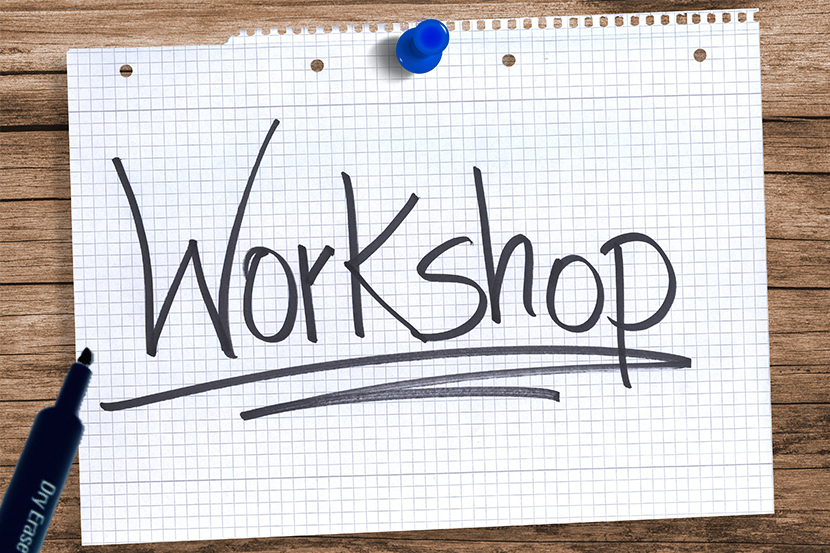 Paper tacked to the desk with the word "Workshop" written on it and underlined, along with a pen next to the paper