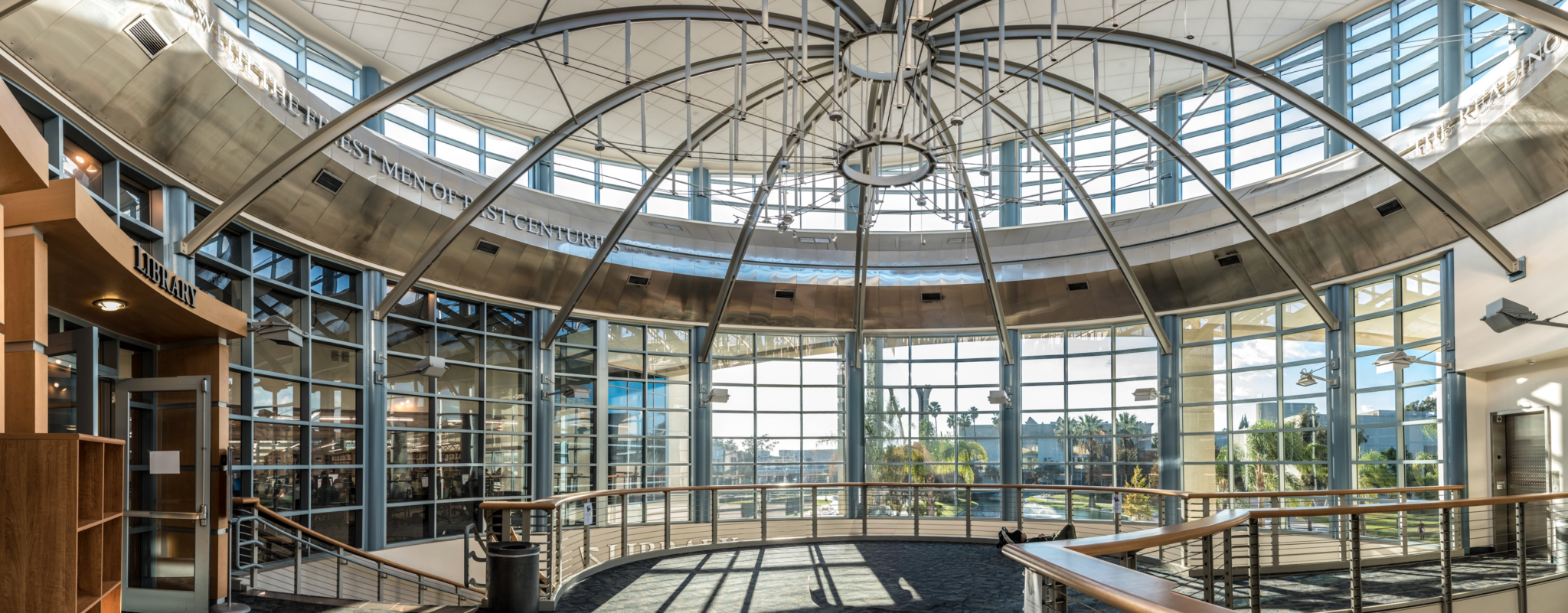 A photo facing upward toward the top of the library rotunda, which is surrounded by windows and supported by exposed, curved, metal beams.