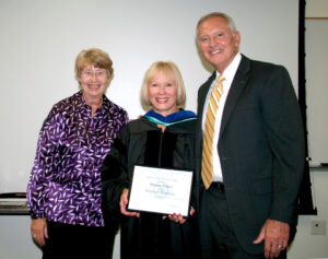 Three people pose for a photograph.