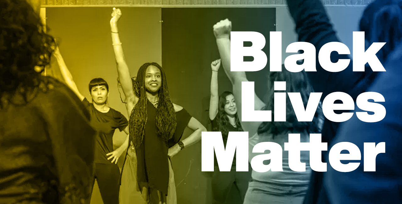 Students with their arms raised in the air, fists clenched with words "Black Lives Matter"