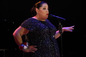 Woman at microphone at the 42nd Americana Awards