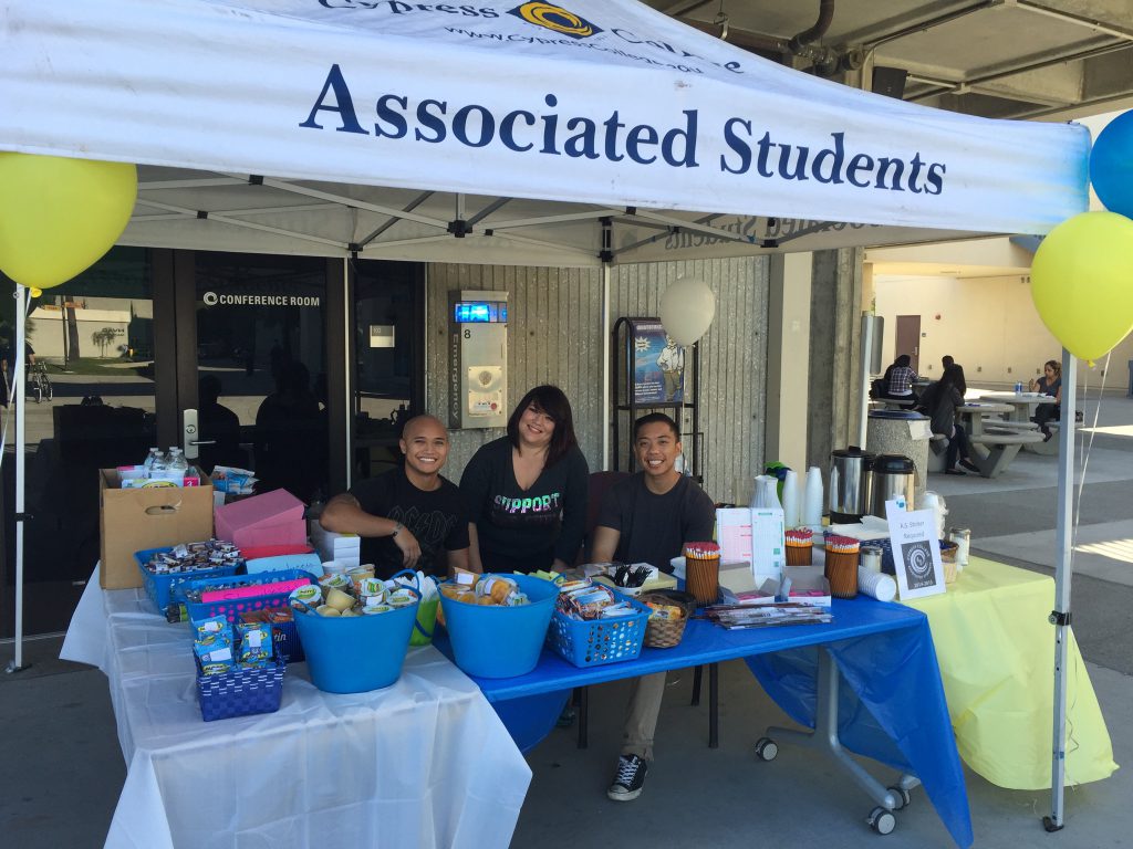 Students behind a table giving away snacks and supplies