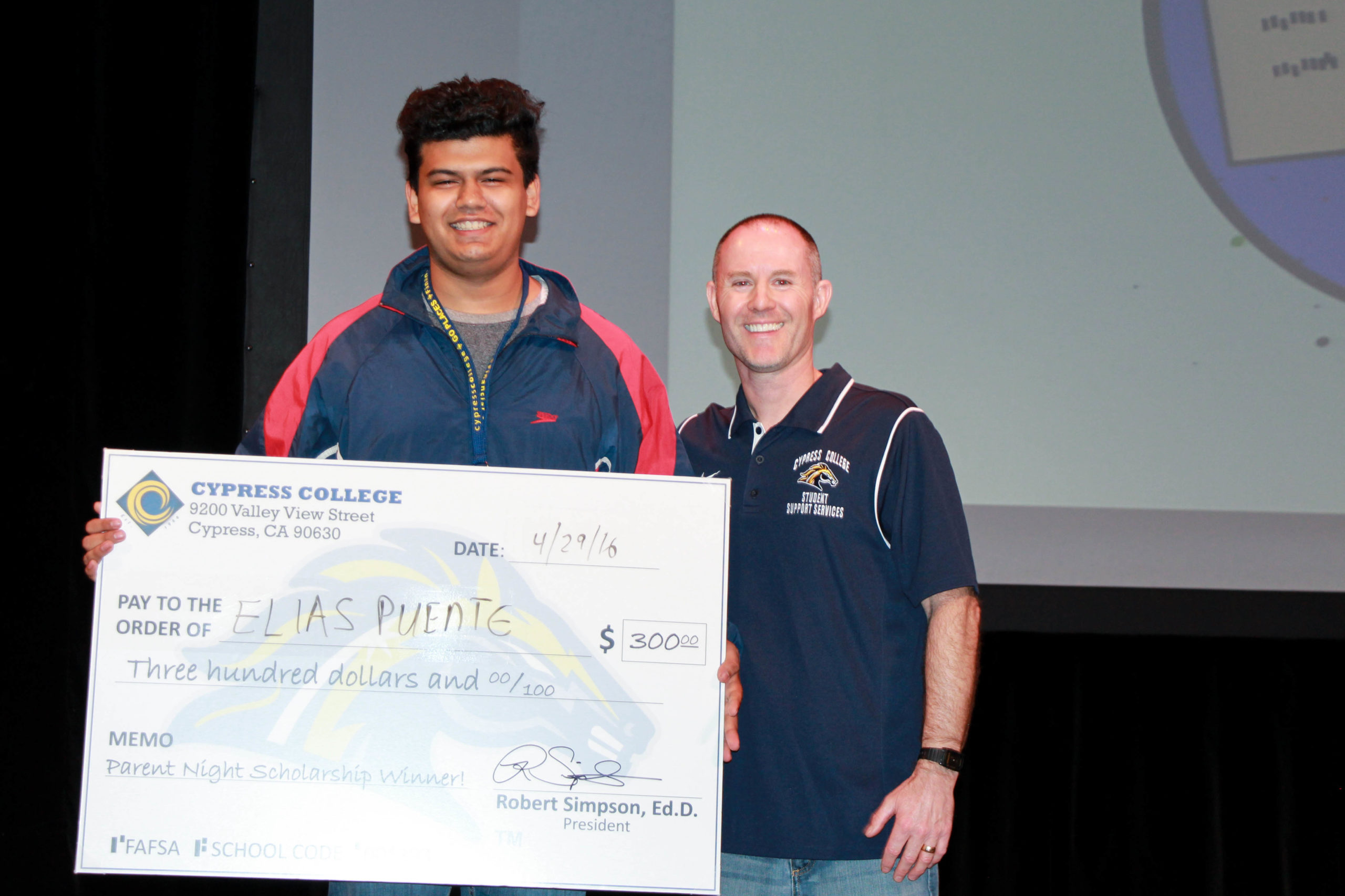 Cypress College Parent Night scholarship winner Elias Puente holding check.