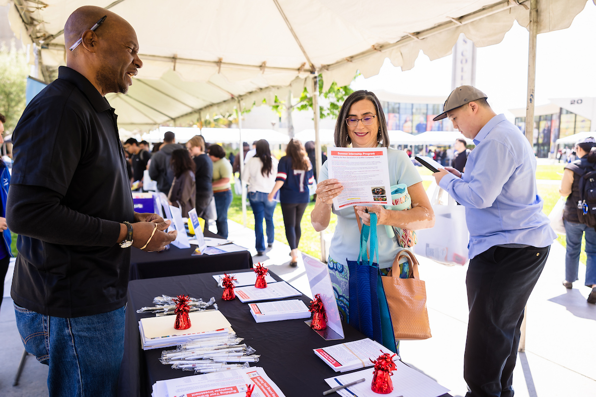 A job-hunter reviews handouts from an employer's table