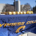 Cypress College table cover with small yellow school buses on display