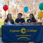 Cypress College Puente students sitting at display table