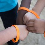 Little hands with orange Cypress College bracelets