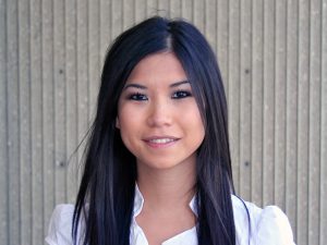 Woman with long straight hair, smiling, wearing white blouse