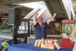 David Okawa with arms up at popcorn booth.