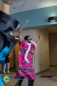 Young man in a pink shirt holding a spear.