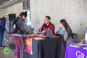 Students talking to representatives of UC and Cal State Universities.