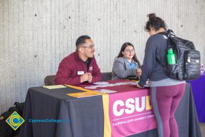 Students talking to representatives of UC and Cal State Universities.