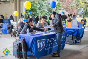 Students talking to representatives of UC and Cal State Universities.