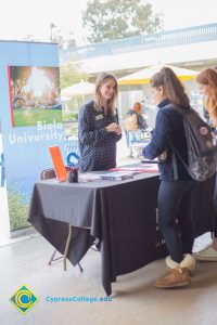 Students talking to representatives of UC and Cal State Universities.