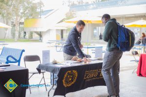 Students talking to representatives of UC and Cal State Universities.