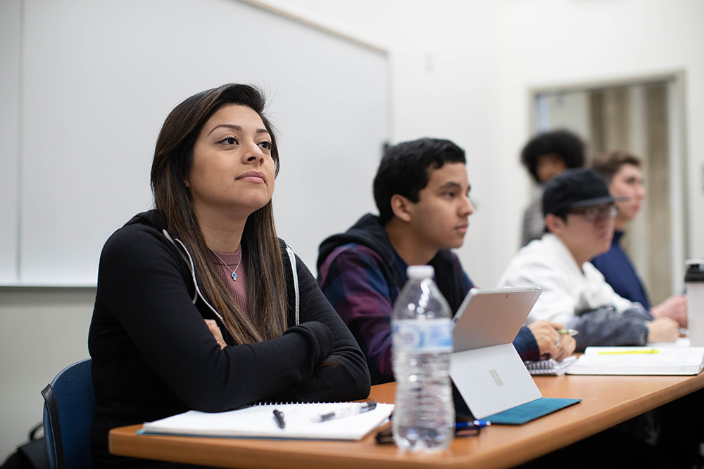 Woman in classroom engaged with lesson.