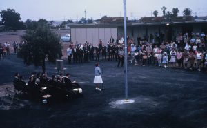 Speaker addressing students outside near flagpole